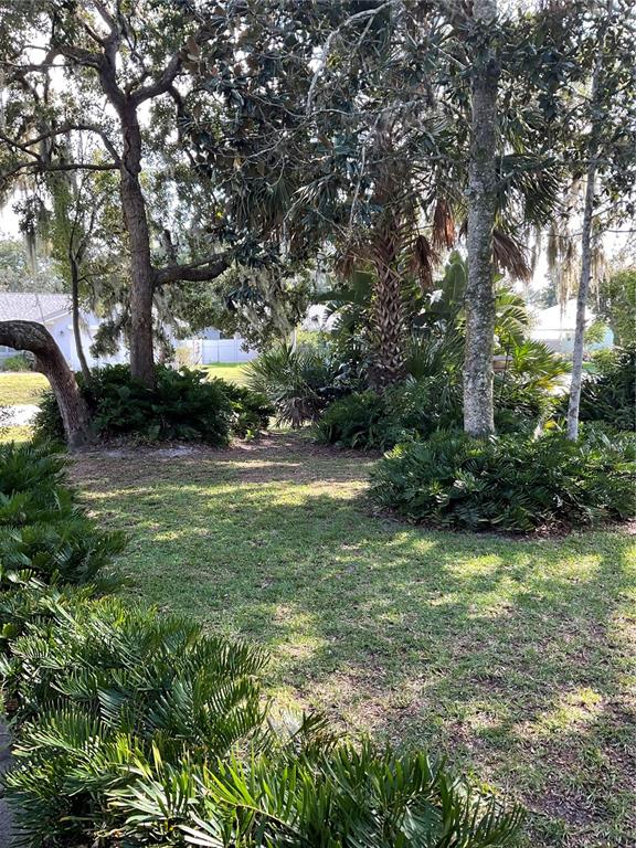 A single-story house with a white chimney, an anchor decoration, and lush landscaping — 88 FREEPORT LANE, PALM COAST, FL