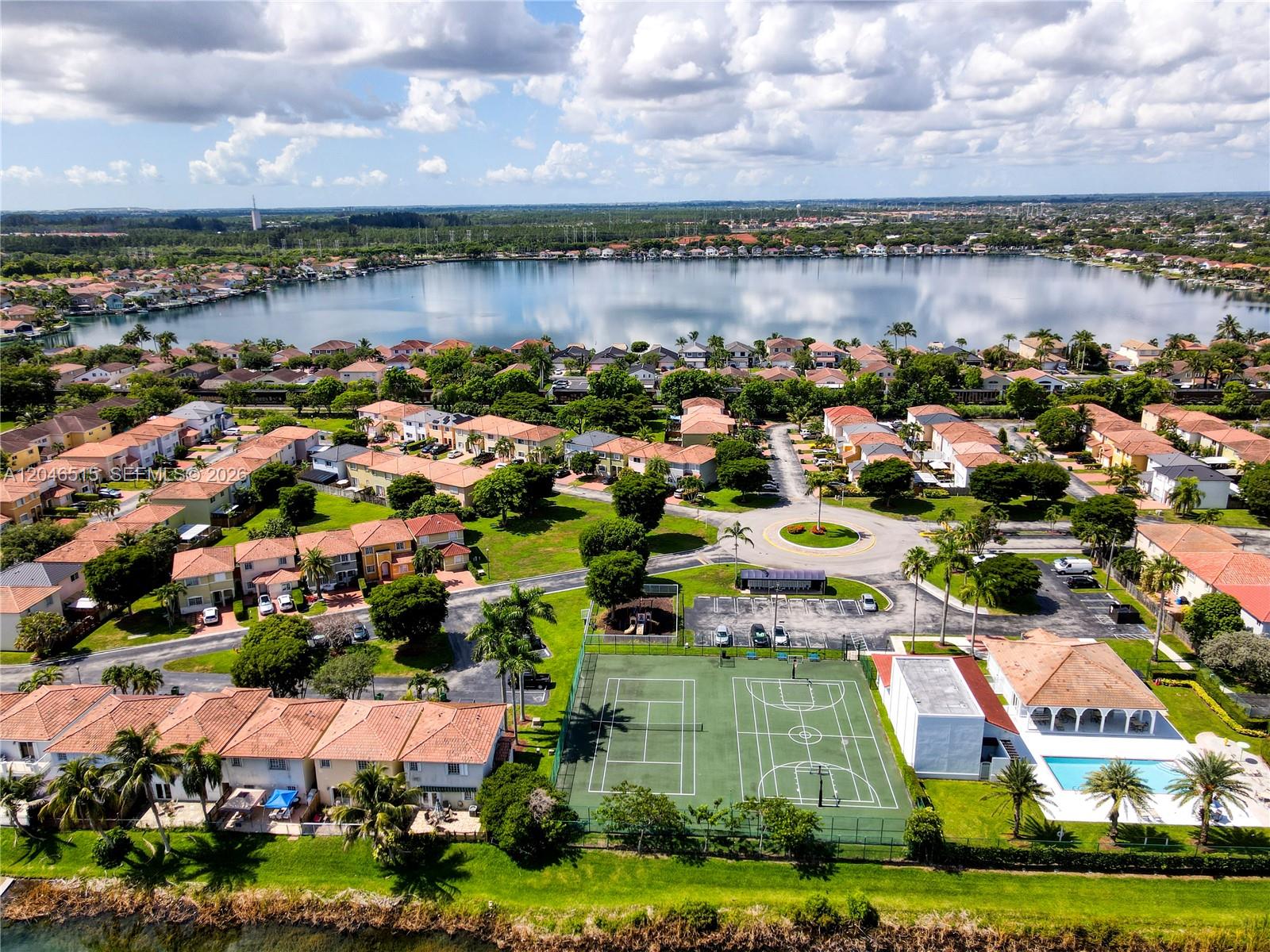 An aerial view shows a residential community with a lake, tennis courts, and a pool — 14302 SW 133rd Ct, Miami FL 33186, MIAMI, FL