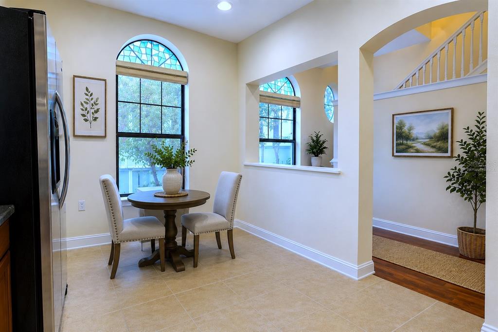 A breakfast nook with a round table, two chairs, and arched windows with stained glass — 4624 MESSINA DRIVE, LAKE MARY, FL