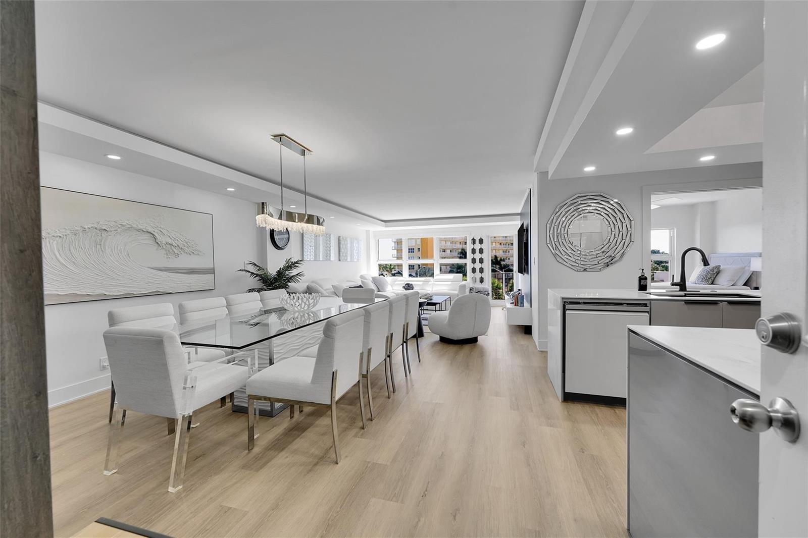 A bright, open-concept living and dining area features light wood floors and modern white furniture — 405 N Ocean Boulevard # 306, Pompano Beach FL 33062, POMPANO BEACH, FL