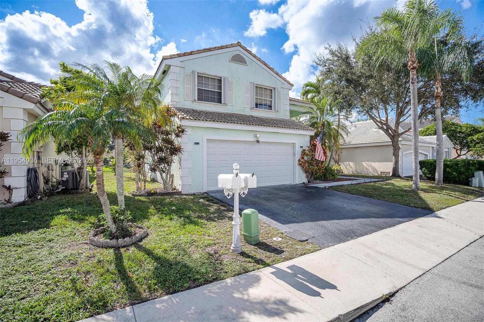 A two-story light green house with a garage and a double mailbox in front — 13930 Oak Ridge Dr, Davie FL 33325, DAVIE, FL