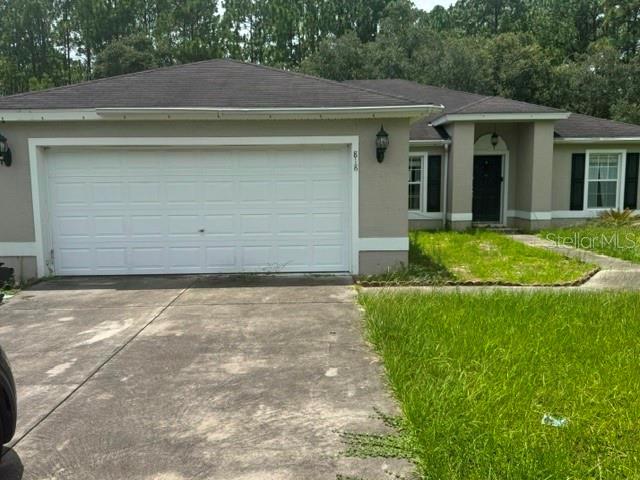 A single-story house features a white garage door, a concrete driveway, and a front entrance — 818 MARION OAKS MANOR, OCALA, FL