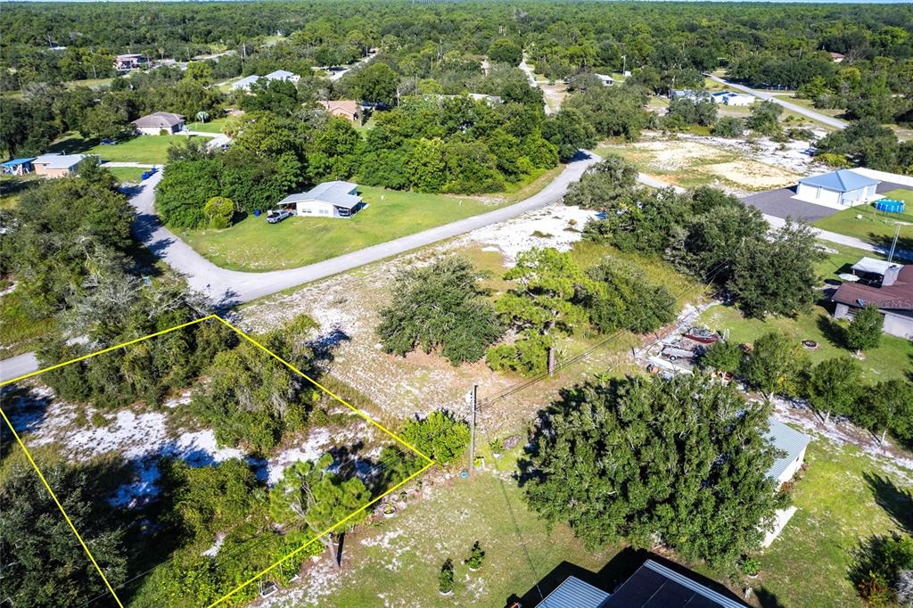 An aerial view shows a vacant, partially wooded residential lot outlined in yellow — 913 HOLLYHOCK COURT, LAKE PLACID, FL