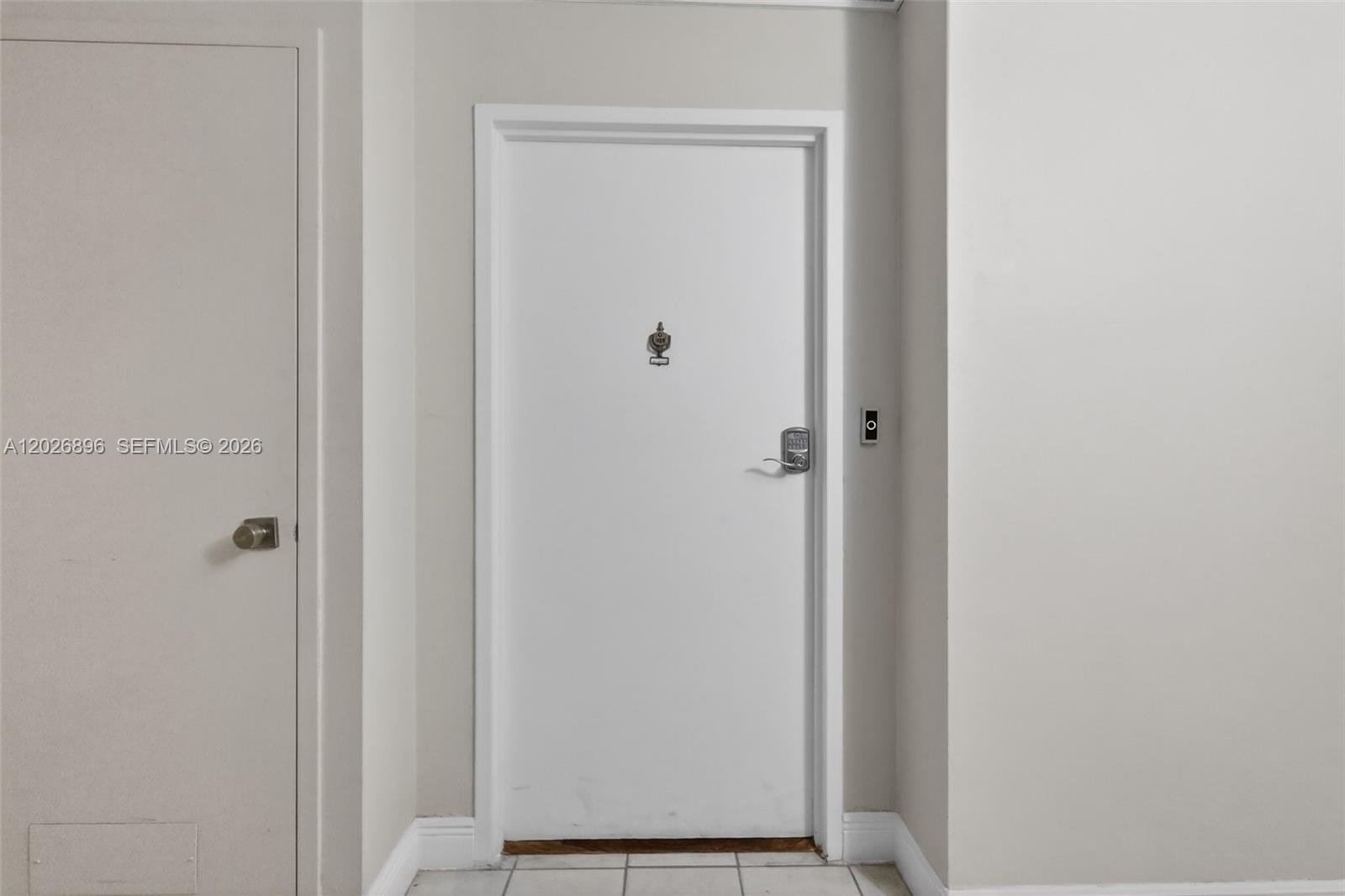 A white door with a digital lock and a door knocker sits between two walls — 7135 Collins Ave # 1124, Miami Beach FL 33141, MIAMI BEACH, FL
