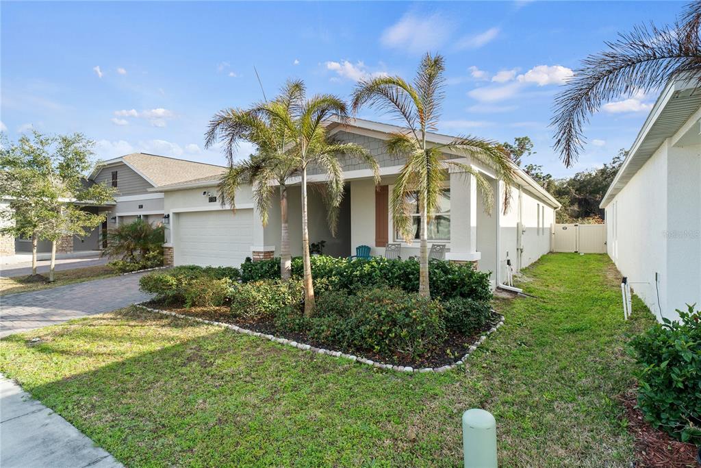 A single-story house with a two-car garage, palm trees, and a landscaped front yard — 1778 GOOD NEIGHBOR LOOP, KISSIMMEE, FL