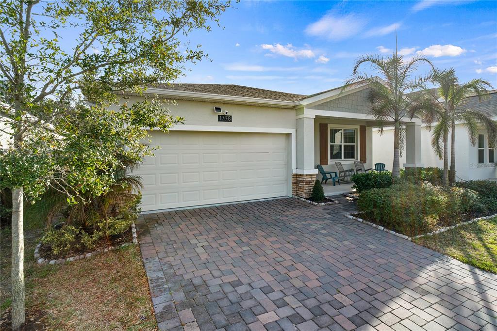 A single-story house features a paved driveway, a two-car garage, and a covered front porch — 1778 GOOD NEIGHBOR LOOP, KISSIMMEE, FL