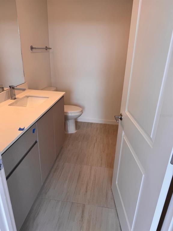 An empty room with light wood-look flooring, white walls, and two windows — 5587 MILLENIA BOULEVARD UNIT 202, ORLANDO, FL