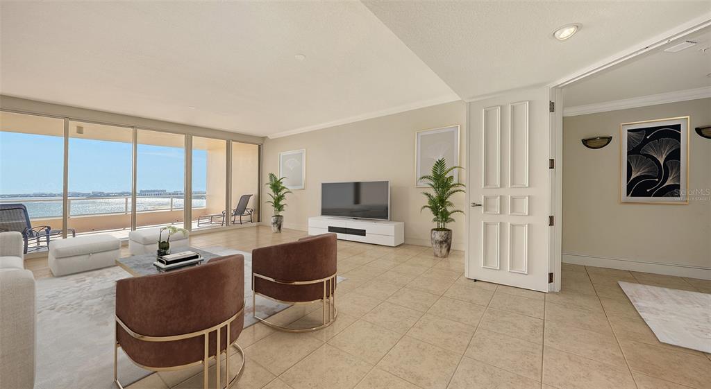 A living room with tile floors, two brown armchairs, a television, and a balcony view — 3010 GRAND BAY BOULEVARD UNIT 493, LONGBOAT KEY, FL
