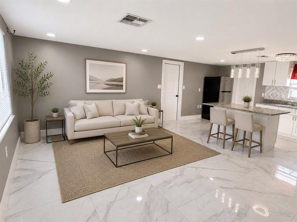 A living room and kitchen area with white marble floors, a sofa, and kitchen island — 9015 PROSPERITY LANE, PORT RICHEY, FL