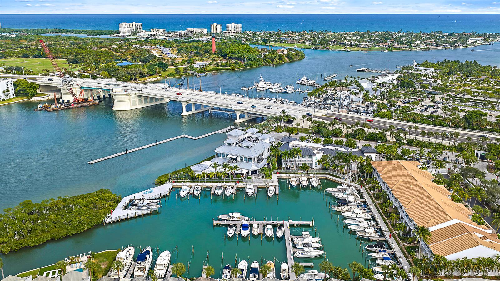 An aerial view shows a marina with numerous boats, a bridge, and a lighthouse — 1000 N Us Highway 1 # 652, Jupiter FL 33477, JUPITER, FL