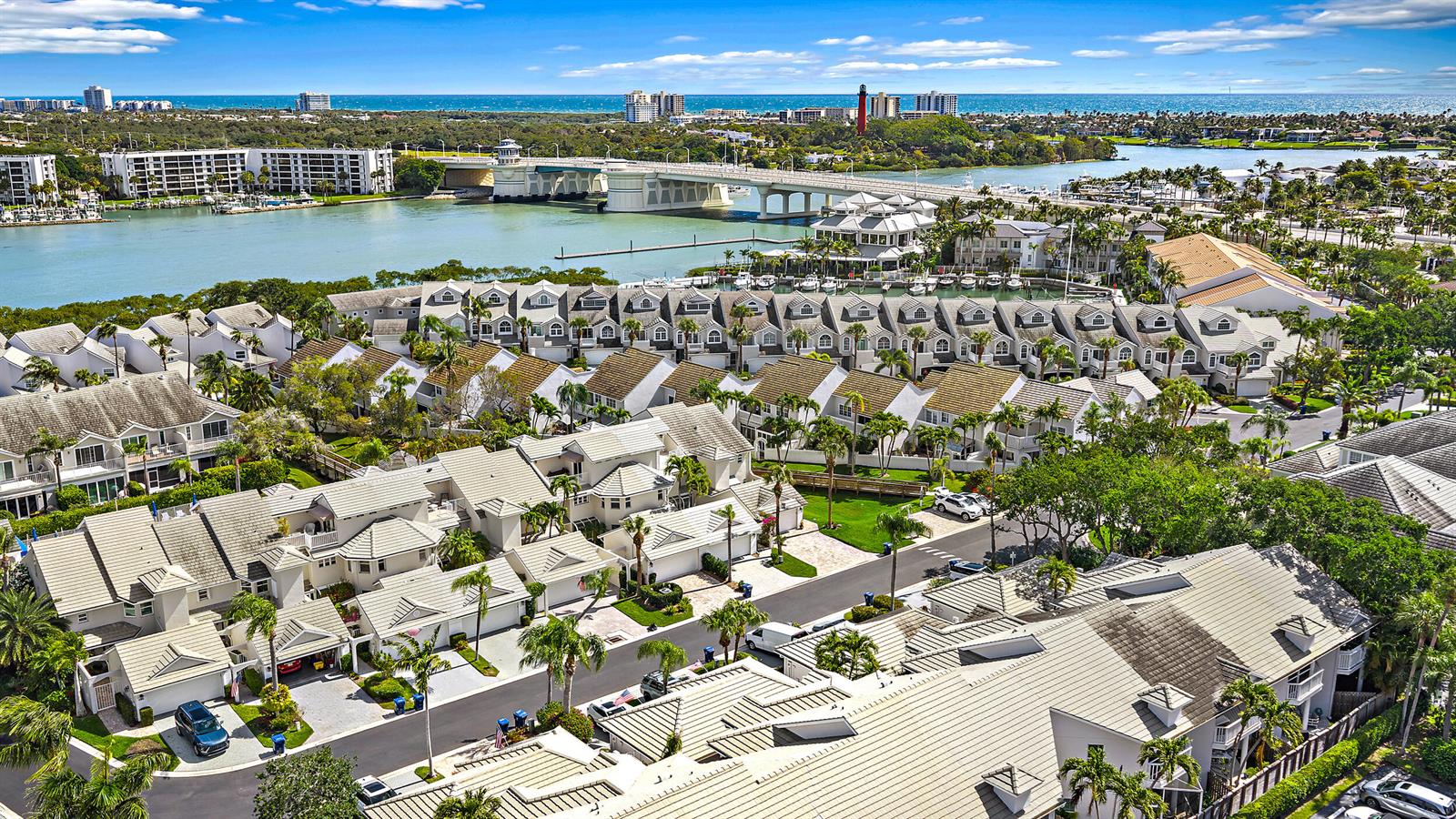An aerial view shows a residential complex with light-colored townhomes near a bridge and water — 1000 N Us Highway 1 # 652, Jupiter FL 33477, JUPITER, FL