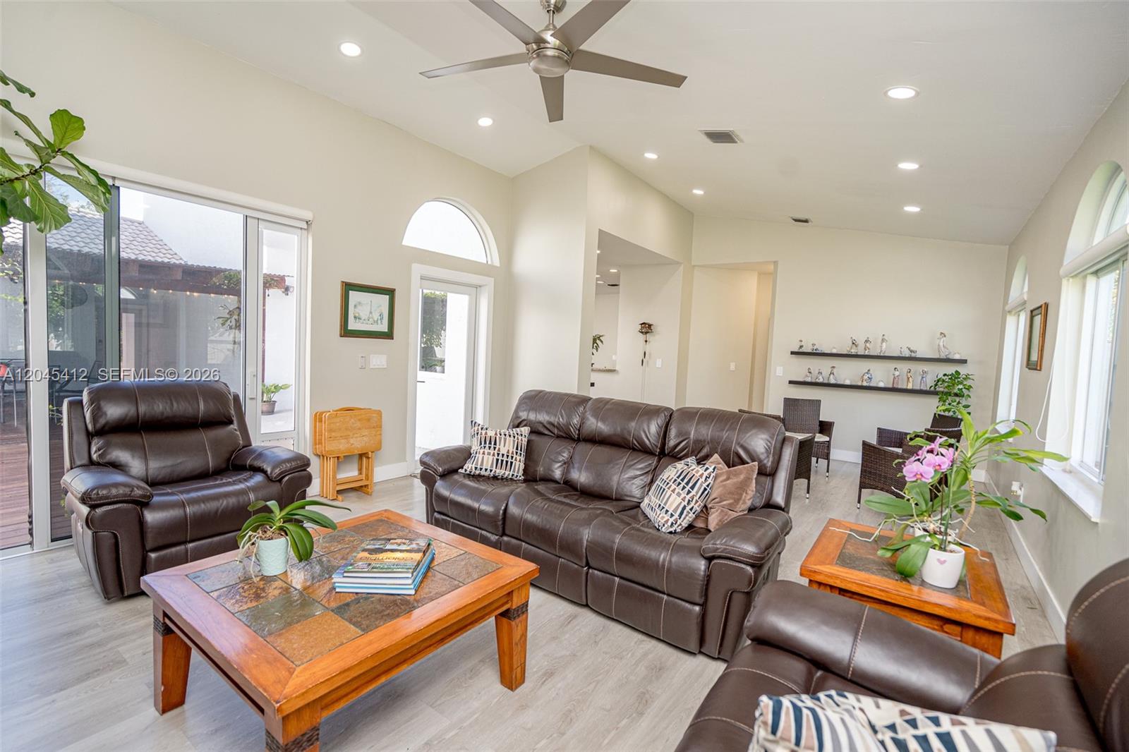 A living room features brown leather furniture, a tile-topped coffee table, and vaulted ceilings — PEMBROKE PINES, FL