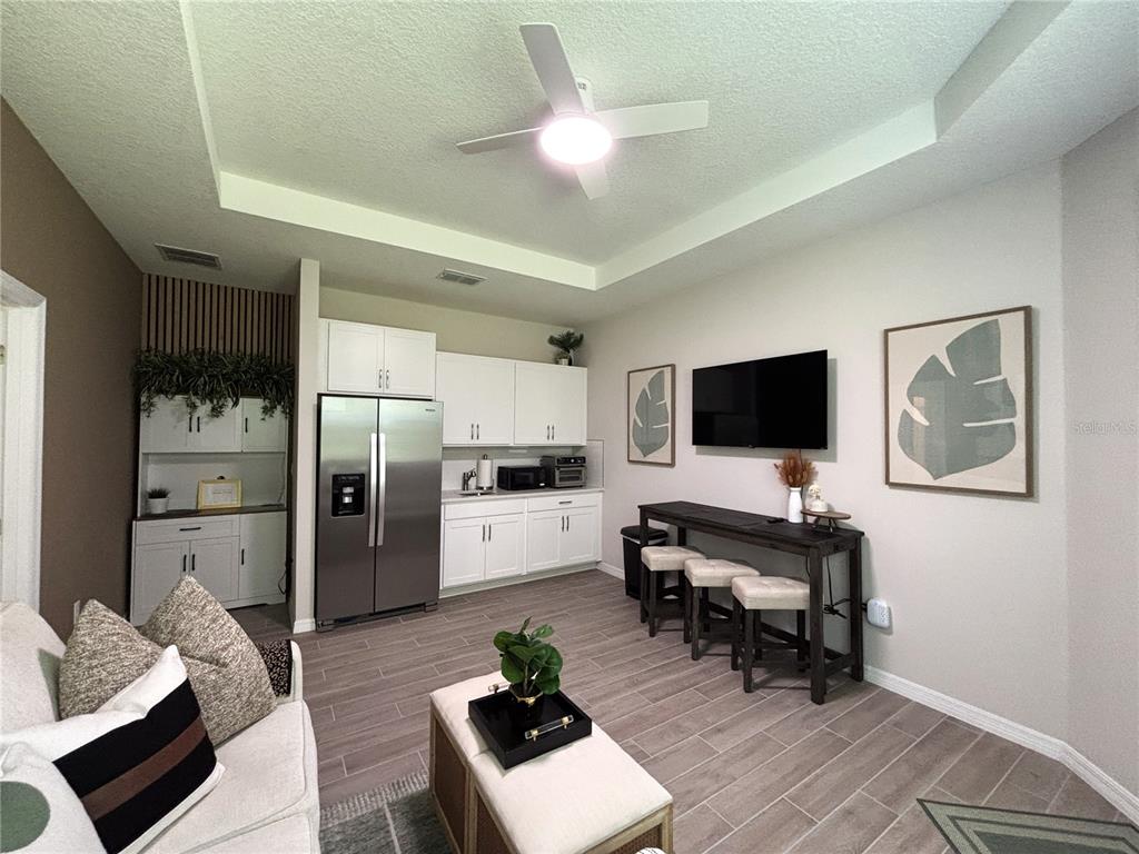 A kitchen and living area features white cabinetry, stainless steel appliances, and a breakfast bar — 2168 GREENWOOD OAK DRIVE, OCOEE, FL
