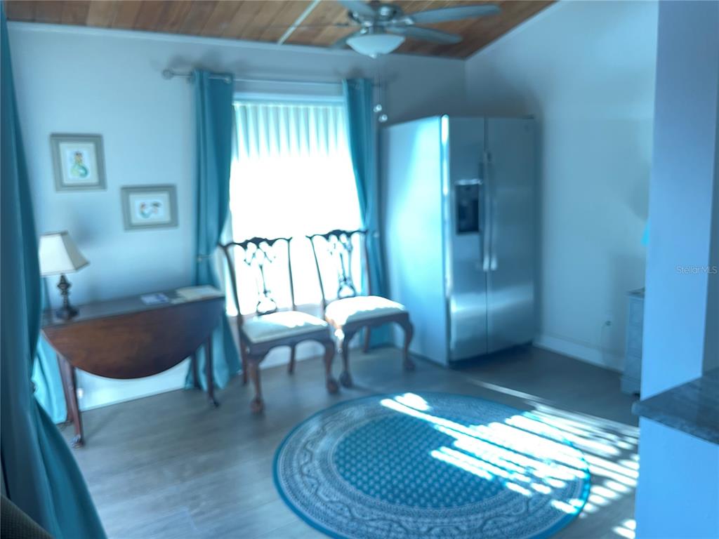 A screened-in balcony features tile flooring, two chairs, a small table, and a water view — 200 MAITLAND AVENUE UNIT 182, ALTAMONTE SPRINGS, FL