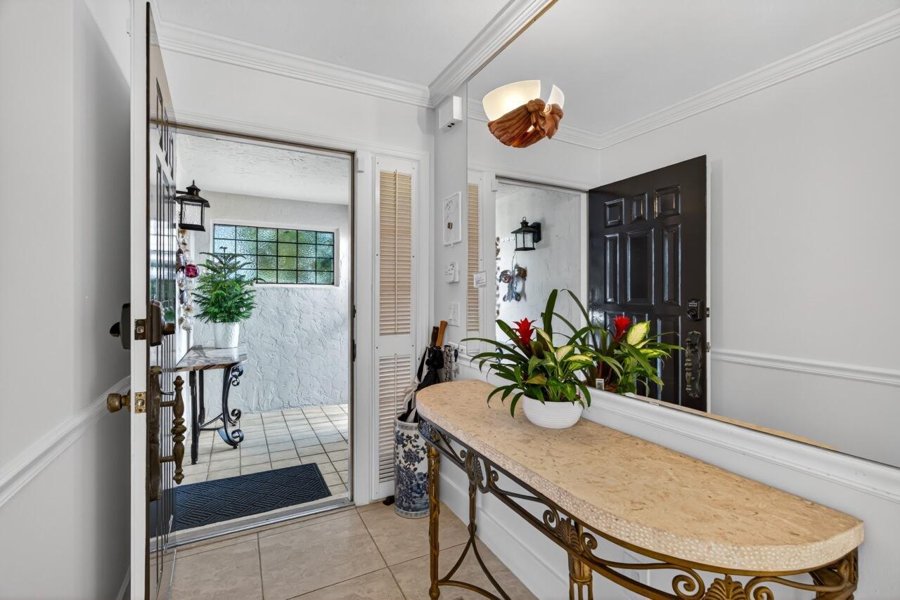 An entryway features a stone-topped console table, a large wall mirror, and an open door — 5790 Jimmy Buffett Mem Highway, Vero Beach FL 32963, VERO BEACH, FL