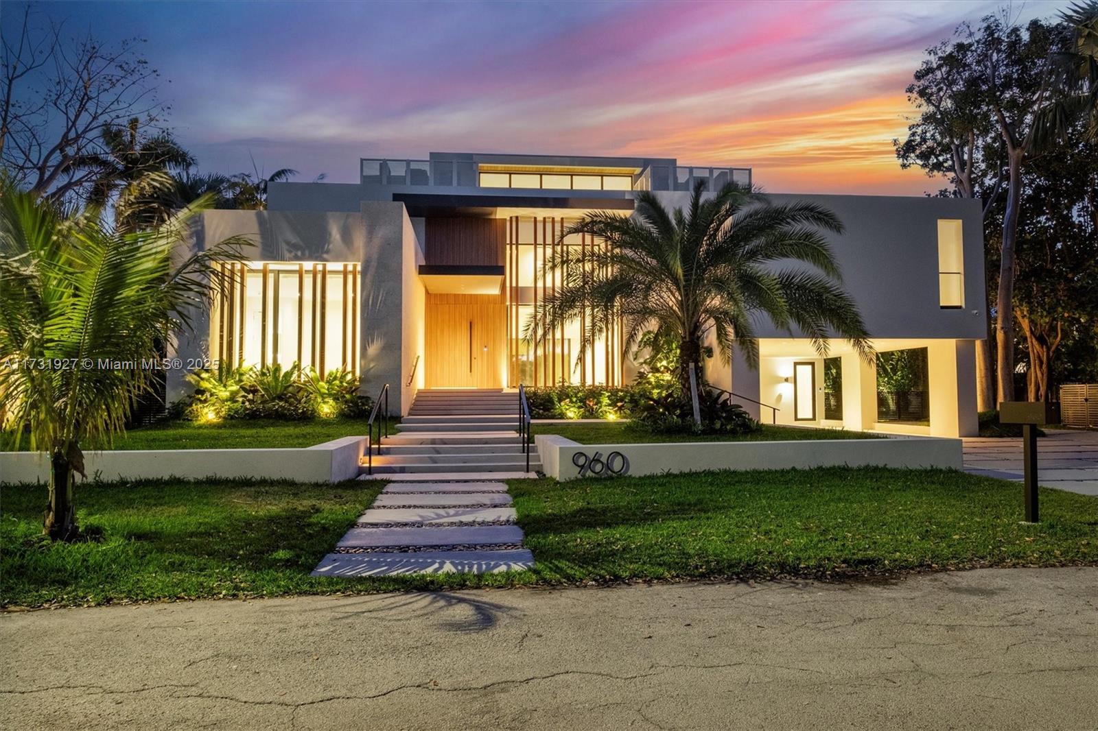 A modern two-story house with a palm tree, illuminated windows, and a stone walkway — 960 Mariner Dr, Key Biscayne FL 33149, KEY BISCAYNE, FL