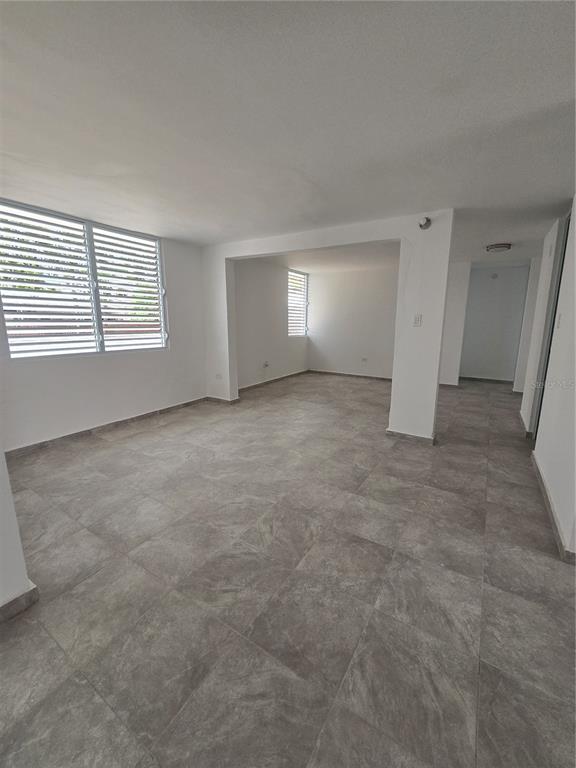 An empty room with gray tile flooring, white walls, and louvered windows — . HIGUERO UNIT P7, CAROLINA, PR
