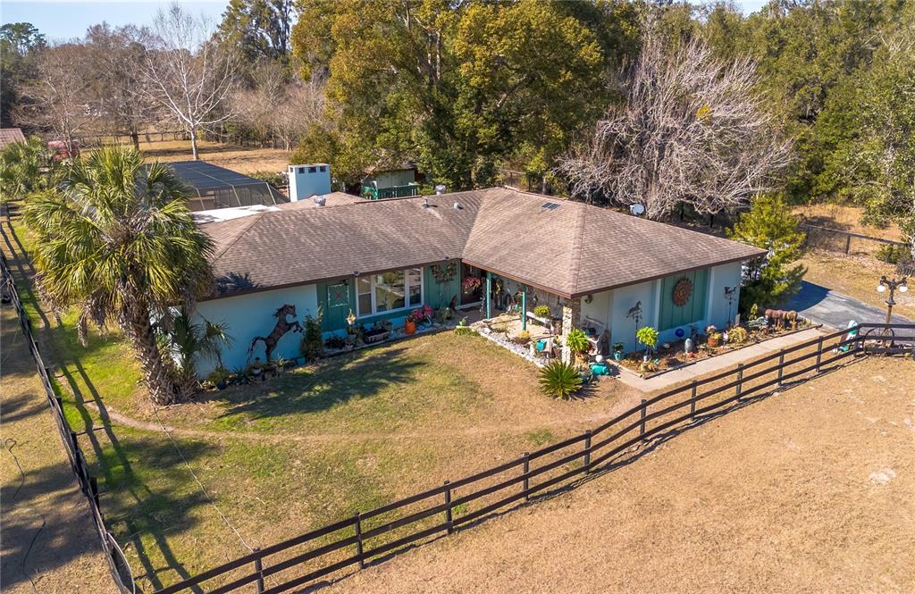 An aerial view of a single-story ranch house with a fenced yard and palm tree — 26 WOOD RIDGE DRIVE, OCALA, FL