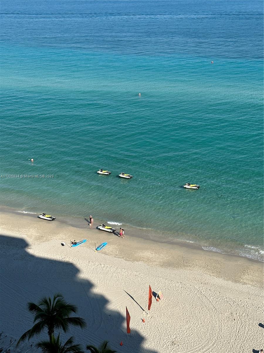 An elevated view of a sandy beach with jet skis in the turquoise water — 3725 S Ocean Dr # 1503, Hollywood FL 33019, HOLLYWOOD, FL