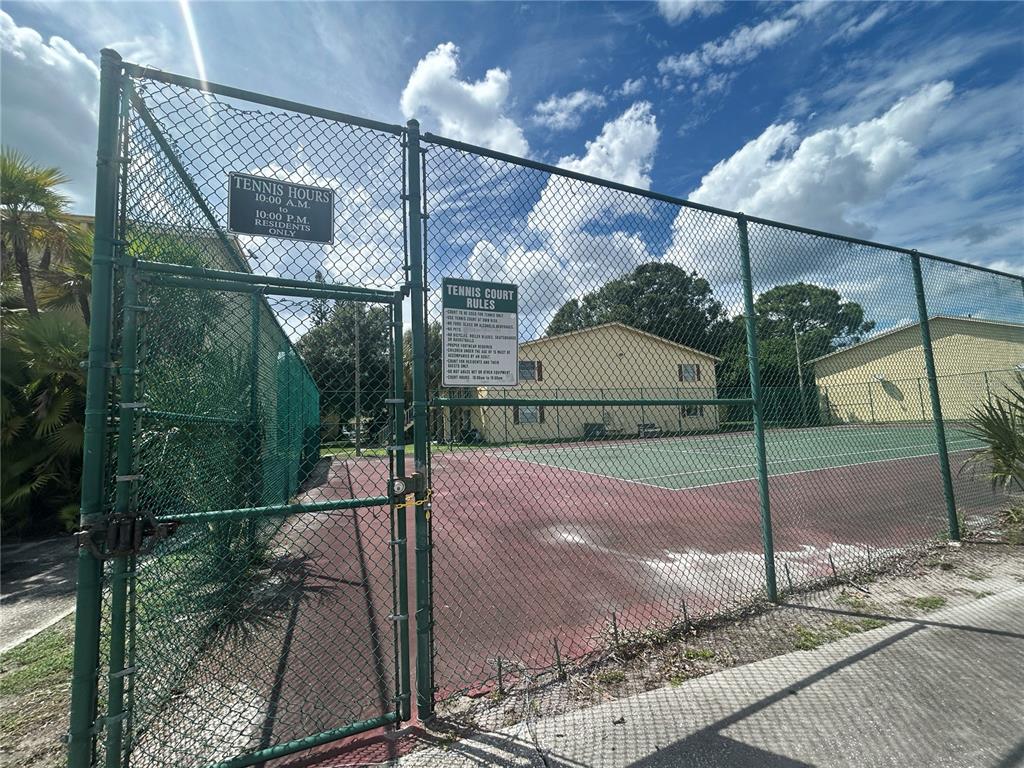 A fenced-in outdoor tennis court with posted rules and hours of operation — 7502 BOLANOS COURT, TAMPA, FL