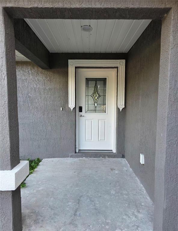 A single-story house with dark gray stucco, a white garage door, and a concrete driveway — 4244 SE 138TH STREET, SUMMERFIELD, FL