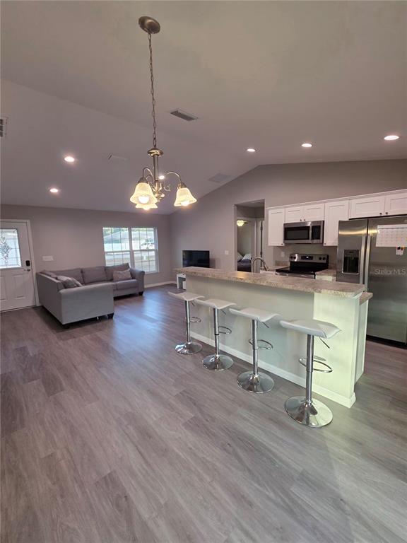 A covered concrete entryway features a white front door with a decorative glass insert — 4244 SE 138TH STREET, SUMMERFIELD, FL