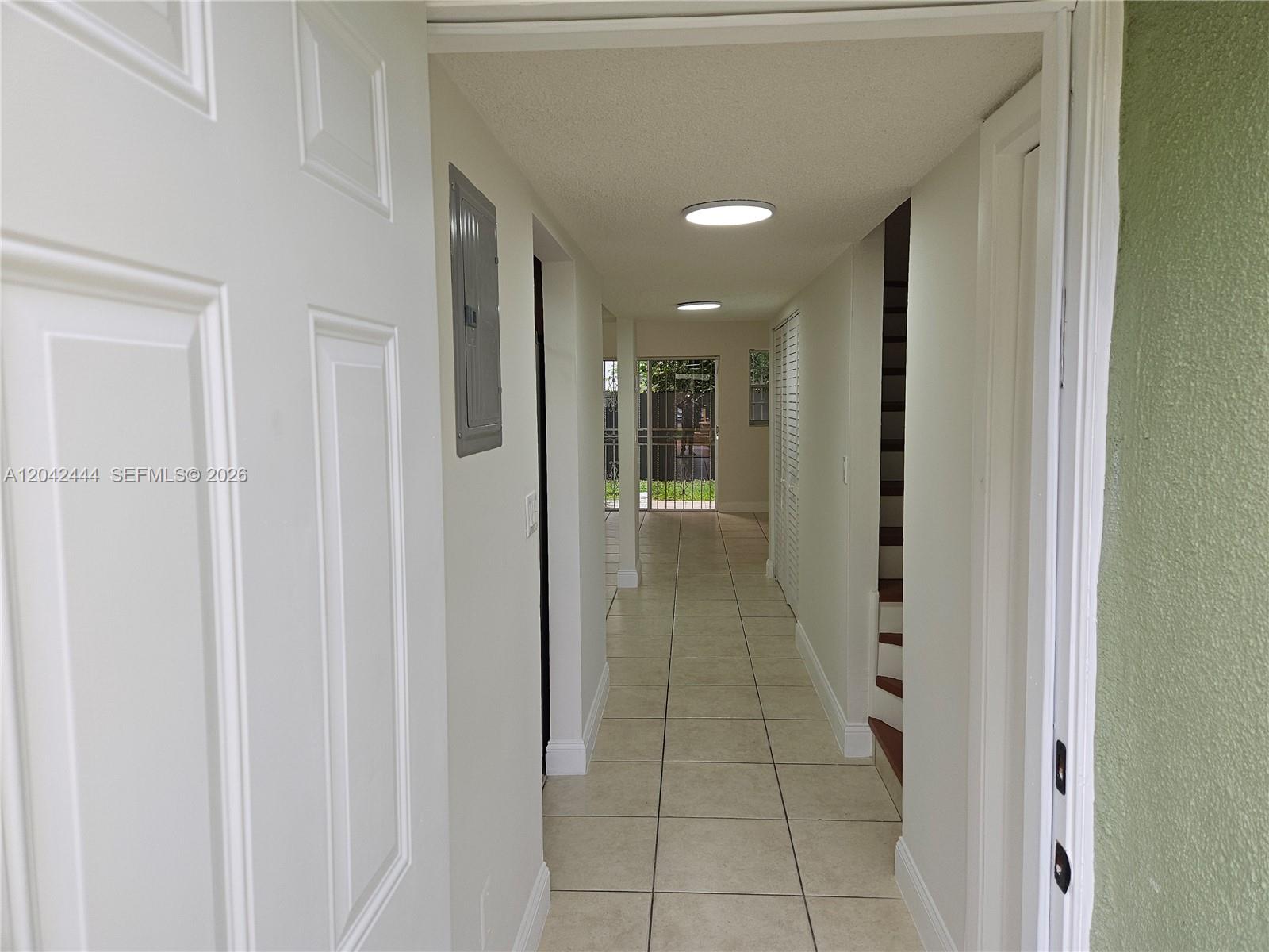 A tiled hallway leads from an open doorway toward a rear door with a screen — 11071 NW 7th St # 15, Miami FL 33172, MIAMI, FL
