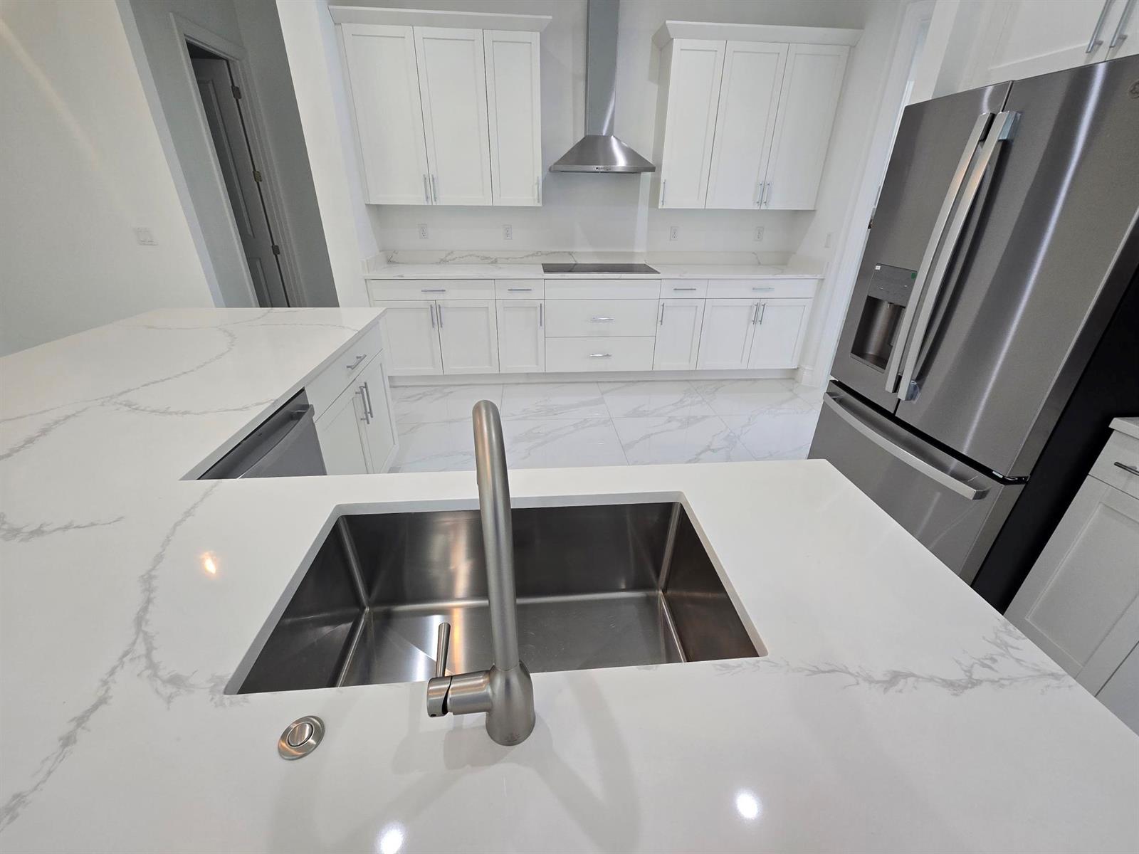 A modern kitchen features white cabinetry, marble-patterned countertops, stainless steel appliances, and a central island — 14974 N 77th Pl Place N, Loxahatchee FL 33470, LOXAHATCHEE, FL