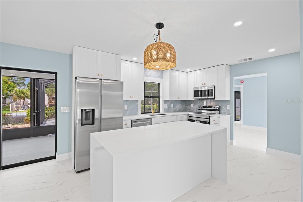 This is a digitally staged living and dining room with light blue walls and tile flooring — 1116 76TH STREET NW, BRADENTON, FL