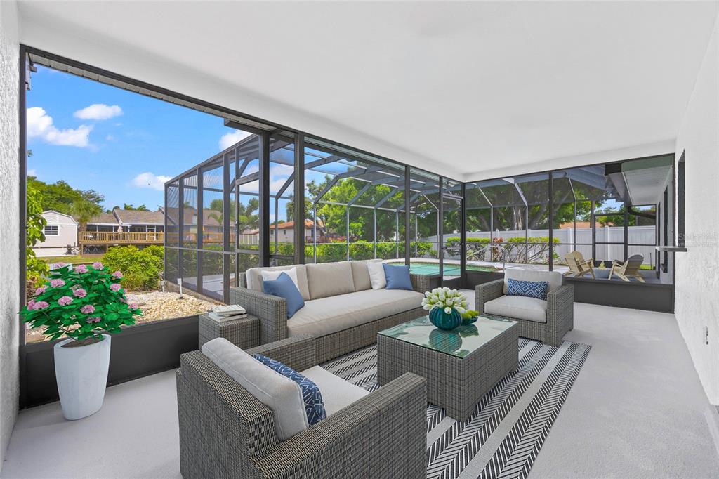 A modern kitchen features white cabinetry, a waterfall island, stainless steel appliances, and light walls — 1116 76TH STREET NW, BRADENTON, FL
