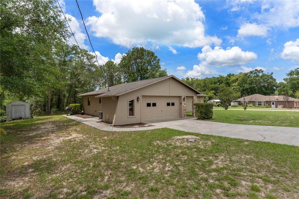A tan, single-story house with a two-car garage and a concrete driveway — 5216 E HOPP LANE, INVERNESS, FL
