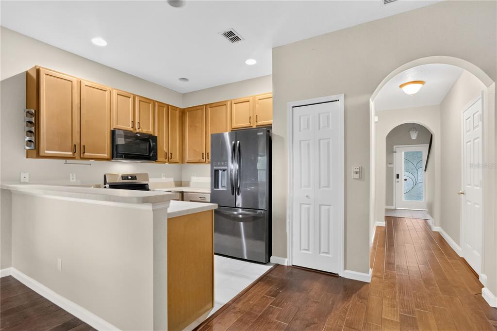 A kitchen with light wood cabinets, stainless steel appliances, and a breakfast bar — 12009 GREAT COMMISSION WAY, ORLANDO, FL