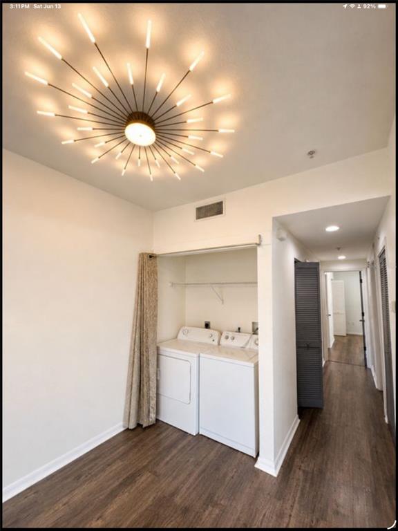 A laundry area with white appliances, a starburst light fixture, and wood-look flooring — 2002 E 5TH AVENUE UNIT 112, TAMPA, FL