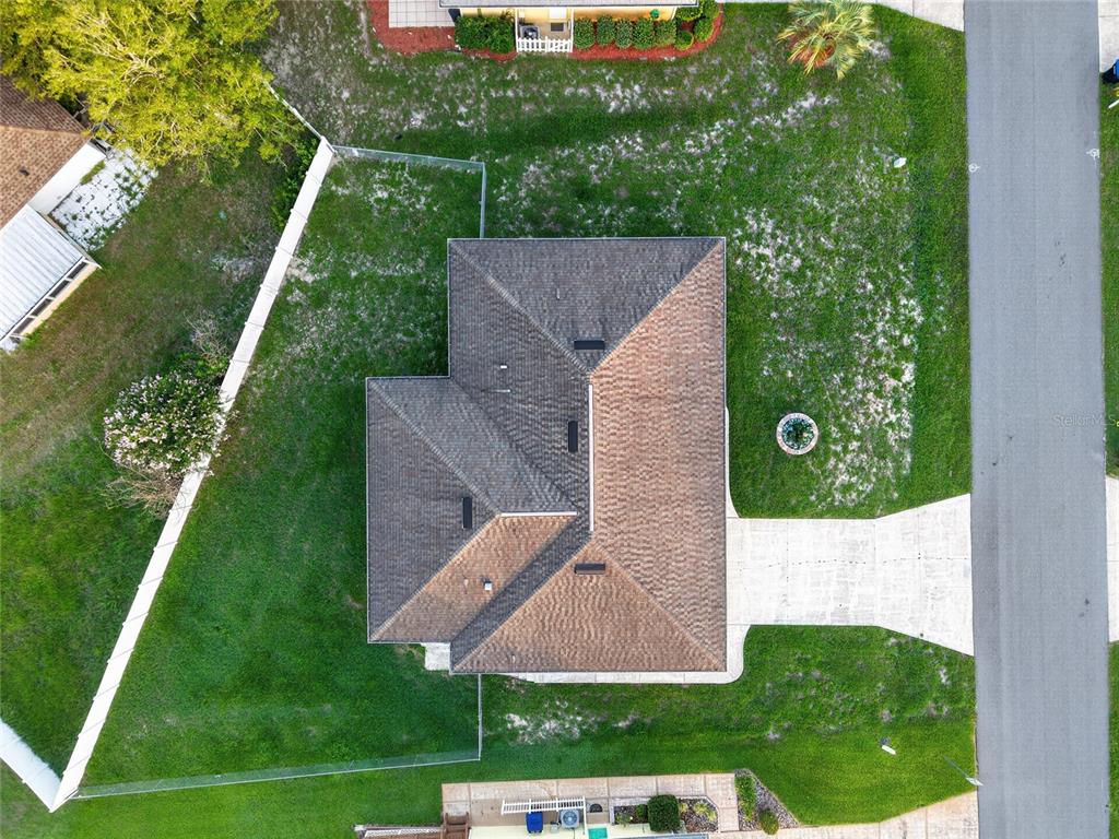 An aerial view shows a house with a shingled roof, driveway, and fenced backyard — 3705 N HONEYLOCUST DRIVE, BEVERLY HILLS, FL