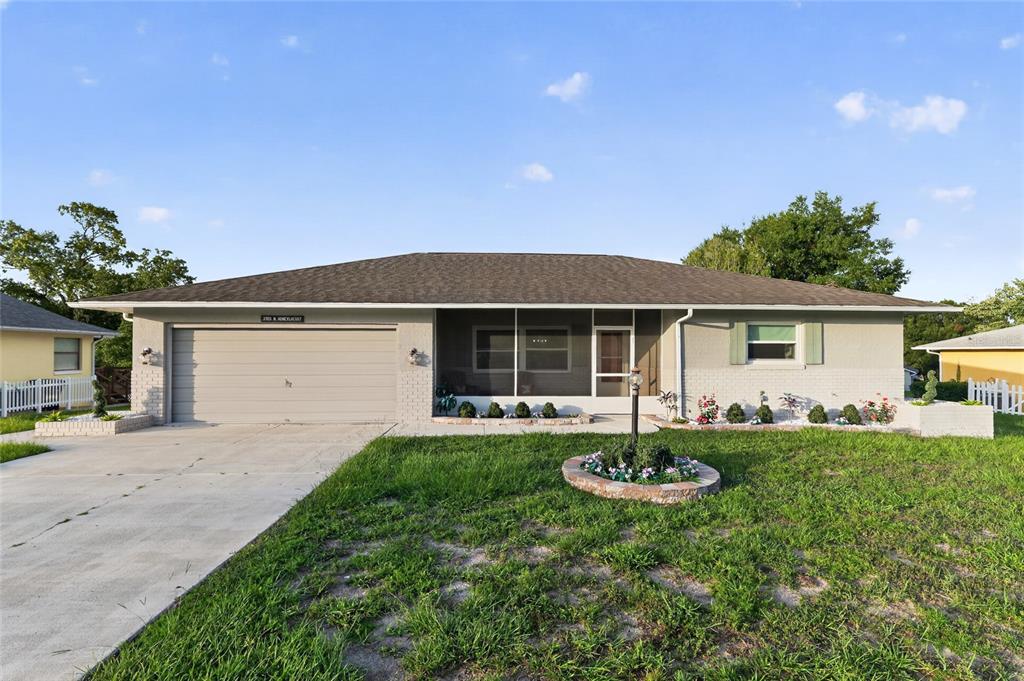 A single-story house with a gray brick exterior, a two-car garage, and a screened porch — 3705 N HONEYLOCUST DRIVE, BEVERLY HILLS, FL