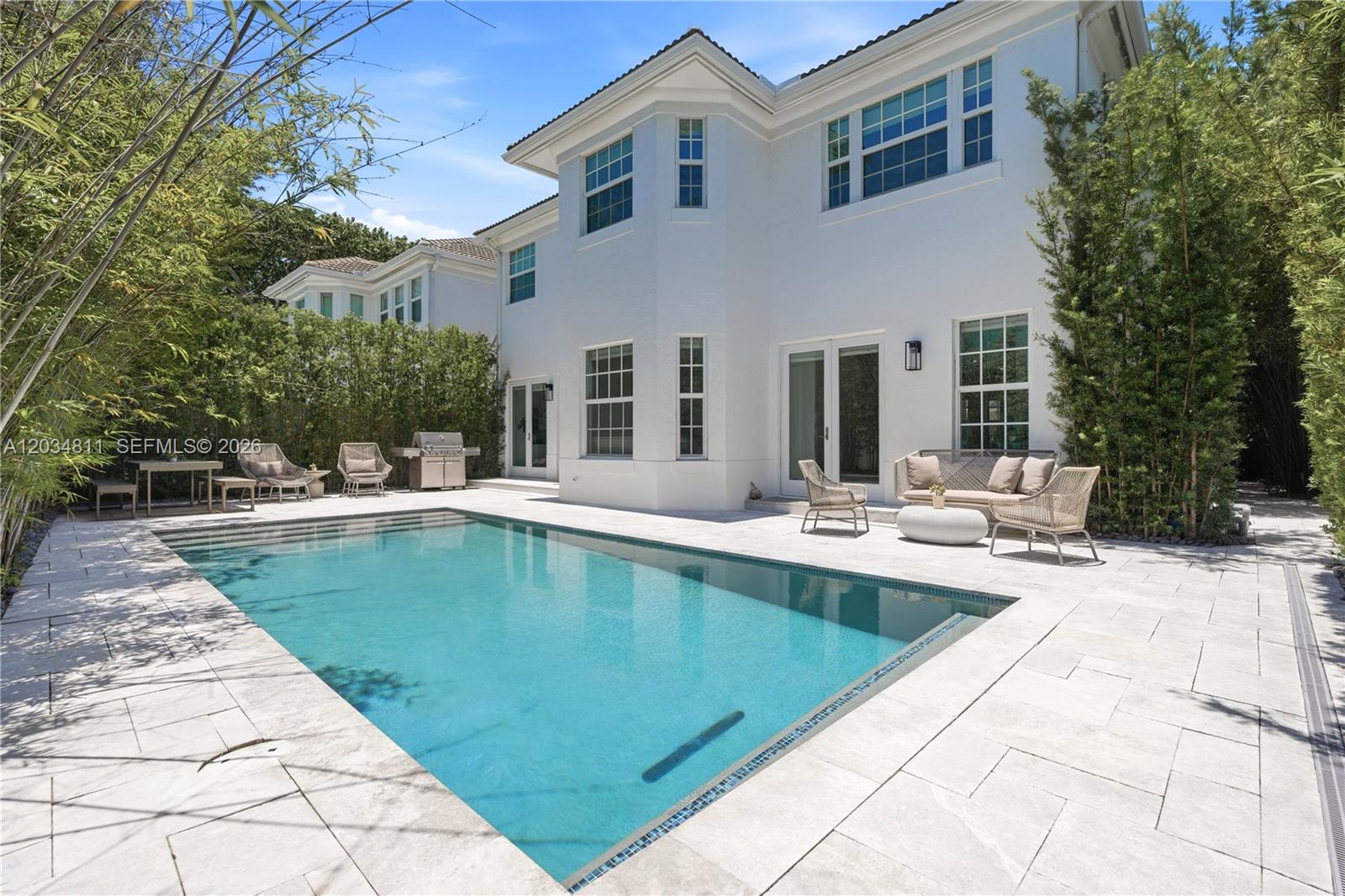 A white two-story house features a rectangular swimming pool and a paved patio area — 19941 NE 36th Pl, Aventura FL 33180, AVENTURA, FL