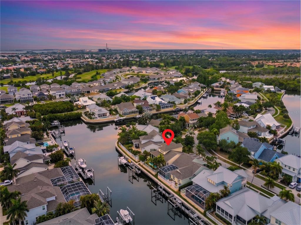 An aerial view of a waterfront house with a pool and boat dock at sunset — 432 ISLEBAY DRIVE, APOLLO BEACH, FL