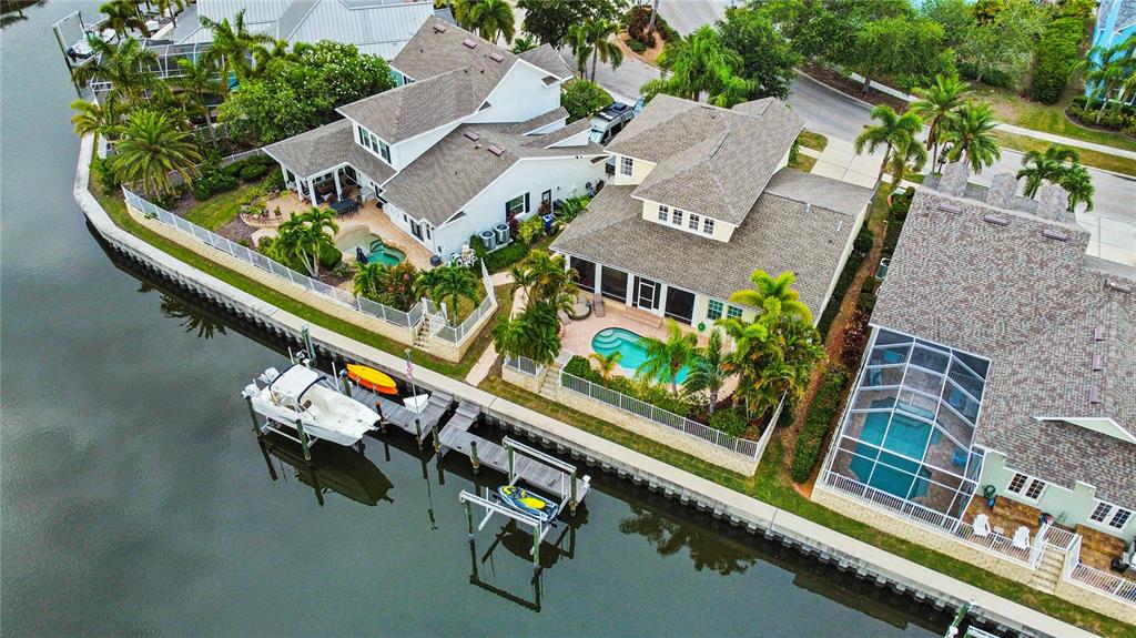 An aerial view shows three waterfront houses with private swimming pools and boat docks — 432 ISLEBAY DRIVE, APOLLO BEACH, FL