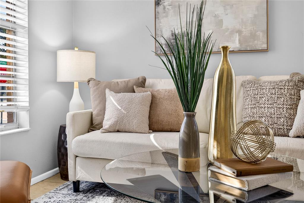A living room features a beige sofa, a glass coffee table, and decorative accents — 3610 SAMMY COURT, PALM HARBOR, FL