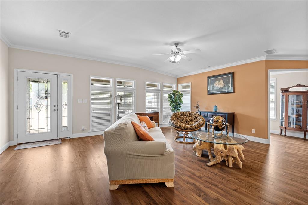 A living room features wood flooring, a beige sofa, a glass-topped coffee table, and windows — 2715 9TH AVENUE N, ST PETERSBURG, FL