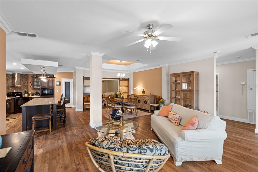 An open-concept living and dining area features wood flooring, a kitchen island, and neutral walls — 2715 9TH AVENUE N, ST PETERSBURG, FL