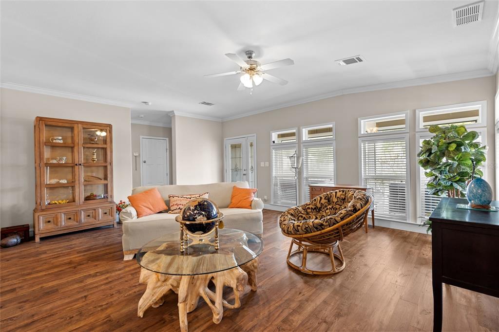 A living room features wood flooring, a glass-topped root coffee table, and a ceiling fan — 2715 9TH AVENUE N, ST PETERSBURG, FL