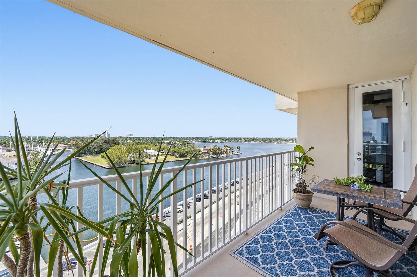 A balcony with a blue patterned rug, patio furniture, and a view of the water — 1401 S Ocean Drive, Hollywood FL 33019, HOLLYWOOD, FL