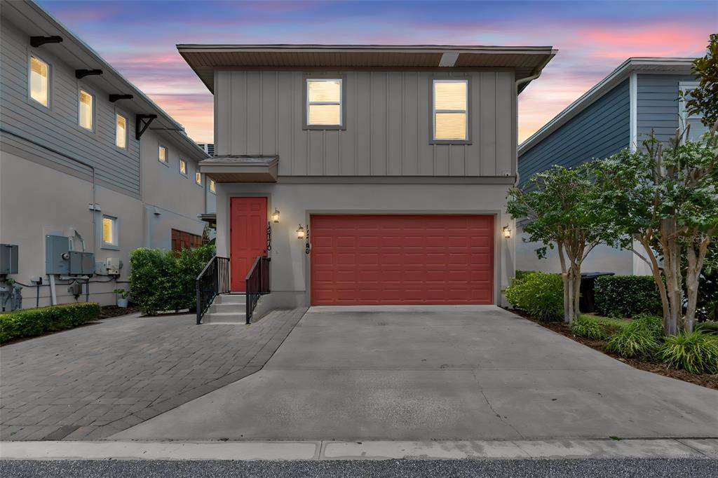 A two-story house features a red front door, a red garage door, and a concrete driveway — 13770 ROSBASH ALLEY, ORLANDO, FL