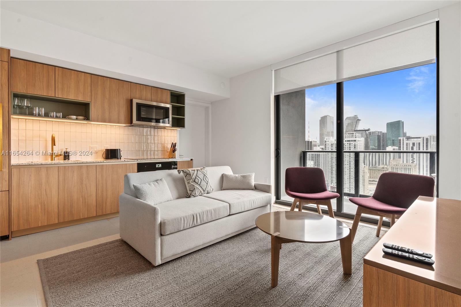 A modern studio apartment features a kitchenette, a sofa, and floor-to-ceiling windows with city views — 601 NE 1st Ave # 2905, Miami FL 33132, MIAMI, FL