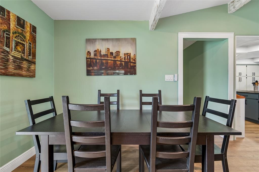 A dining room features a dark wood table and chairs against a light green wall — 5150 SOUTHWIND DRIVE, MULBERRY, FL
