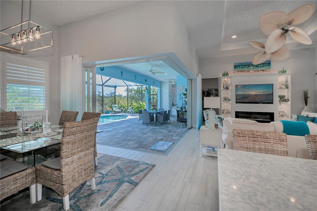 An open-concept living and dining area features a large sliding door opening to a pool — 10136 AMY TERRACE, PORT CHARLOTTE, FL