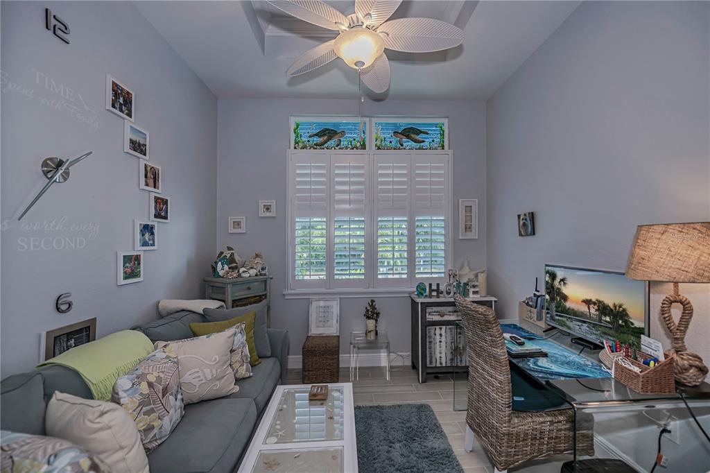 A home office features a sofa, a desk with a computer, and a ceiling fan — 10136 AMY TERRACE, PORT CHARLOTTE, FL