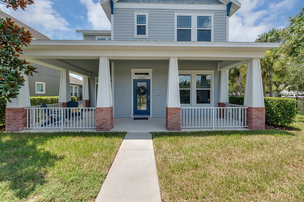 A two-story house with a blue door, a covered front porch, and brick-based columns — 14103 BARRINGTON STOWERS DRIVE, LITHIA, FL