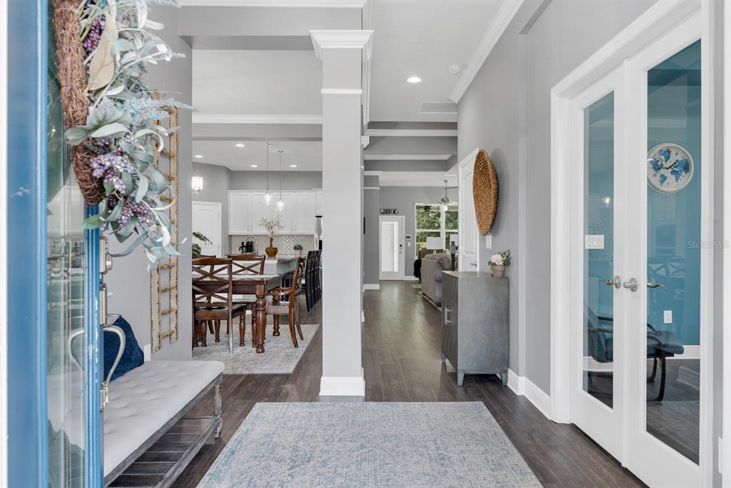 A foyer with dark wood floors leads to an open-concept dining area and kitchen — 14103 BARRINGTON STOWERS DRIVE, LITHIA, FL